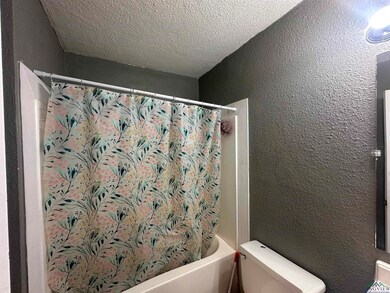 Full bathroom with toilet, shower / tub combo with