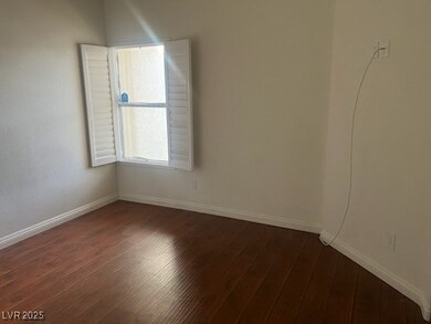 Spare room with dark wood-type flooring and baseboards