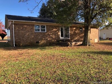 Back of home with small deck/patio.
