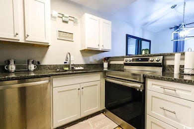 Kitchen with pendant lighting, dark stone counters