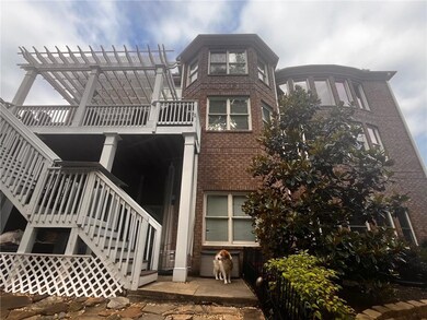 Back of house featuring stairway, brick siding, and a pergola