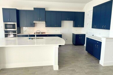 Kitchen with blue cabinetry, tasteful backsplash, wood tiled floors, stainless steel appliances, and a large island
