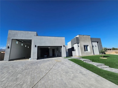 Contemporary home with stucco siding, decorative driveway, a front lawn, and an attached RV garage