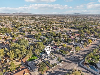 Aerial view of property and surrounding area with nearby suburban area and a mountain backdrop