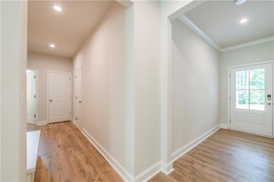 Corridor featuring ornamental molding and light ha