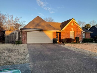 Single story home featuring a garage, brick siding