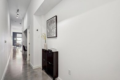Corridor featuring concrete flooring and baseboar