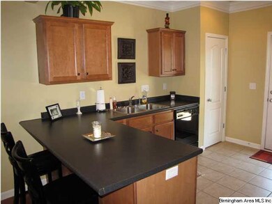 Kitchen features custom cabinets and eat at bar.