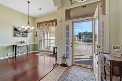 Entrance foyer with dark wood-type flooring and a chandelier