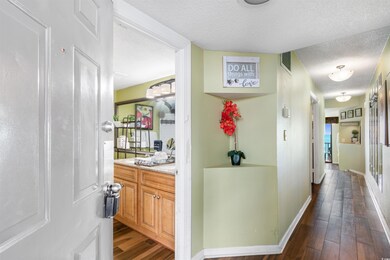 Corridor with a textured ceiling and dark hardwood