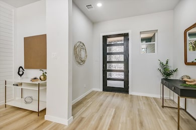 Foyer entrance featuring light wood-style flooring, healthy amount of natural light, and recessed lighting