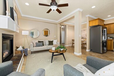 Living area with a glass covered fireplace, crown molding, recessed lighting, and ceiling fan