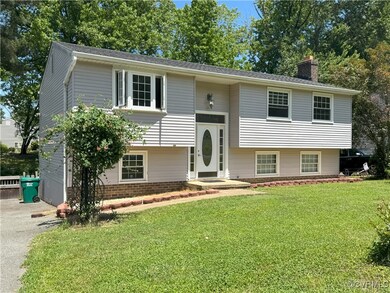 Bi-level home with a chimney and a front lawn