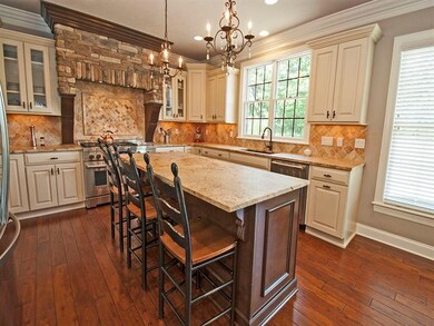 THIS KITCHEN BOASTS A LARGE ISLAND, MINI CHANDELIE