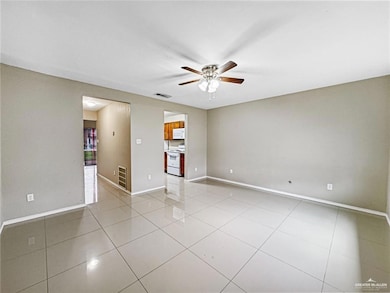 Tiled empty room featuring ceiling fan