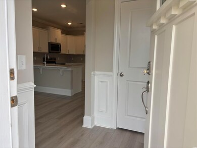 Kitchen featuring stainless steel appliances, a kitchen bar, light wood-style floors, decorative backsplash, and ornamental molding