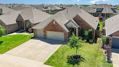 French country inspired facade featuring brick siding, an attached garage, and a residential view