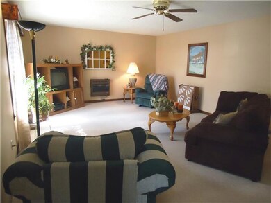 The living room is large and welcoming with bright, sunny windows, celing fan and carpeting.