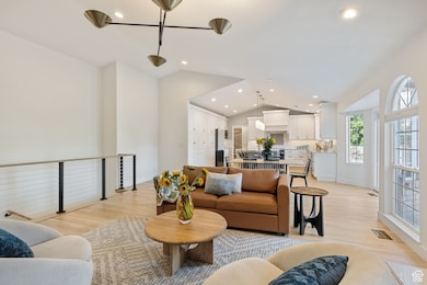 Living room with light wood-style flooring, recessed lighting, and high vaulted ceiling