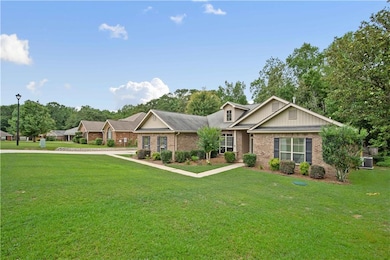 View of front of home featuring brick siding, a front lawn, and central AC