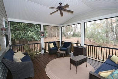 Inviting screened in porch featuring ceiling fan, 