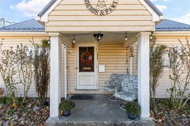 Doorway to property with a metal roof, covered porch, and an attached garage