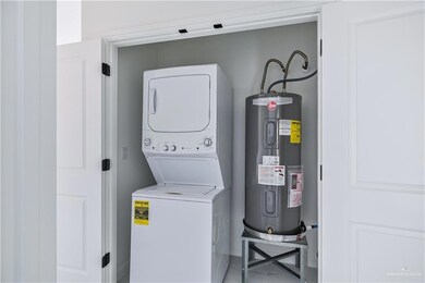 Washroom with stacked washer / drying machine and water heater
