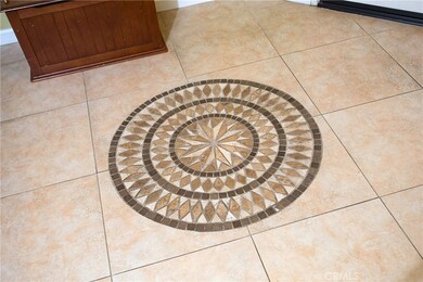 Large tiles throughout downstairs and decorative mosaic pattern in front entrance foyer.