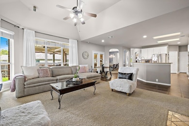 Living room with arched walkways, a ceiling fan, 