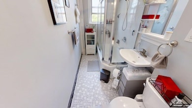 Bathroom featuring a stall shower/deep tub, a sink, baseboards, tile patterned floors, and toilet