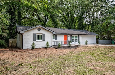 Single story home featuring covered porch, a garage, concrete driveway, brick siding, and a shingled roof