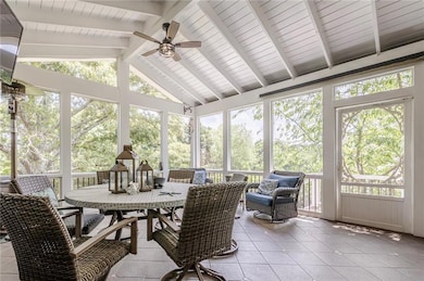 Sunroom / solarium featuring a ceiling fan, outdoo