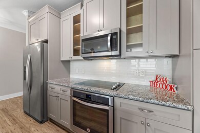 Kitchen featuring tasteful backsplash, light stone