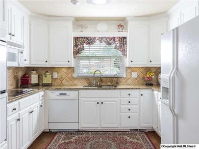 Bright and happy kitchen with granite countertops and popular KitchenAid brand appliances.