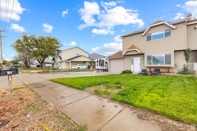 View of front of property featuring concrete driveway, a front yard, and a residential view