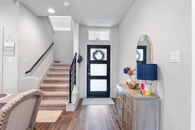 Entrance foyer featuring dark wood-type flooring, stairs, and recessed lighting