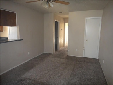 Carpeted empty room featuring baseboards and a cei
