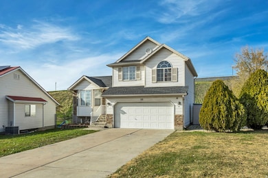 View of front facade featuring a front lawn, concrete driveway, and a garage