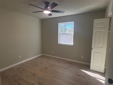 Spare room with wood finished floors and a ceiling fan