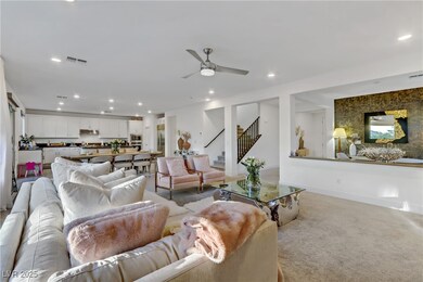 Living area with stairs, light colored carpet, vis