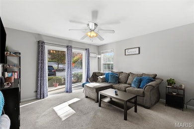 Living area with carpet floors and ceiling fan