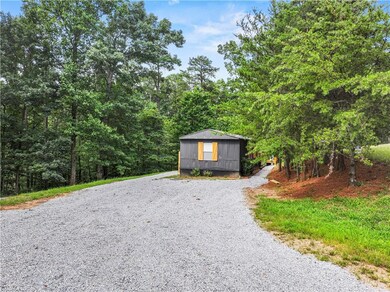 View of outdoor structure featuring gravel driveway