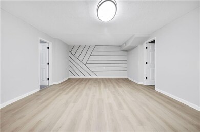 Bonus room with baseboards, a textured ceiling, an