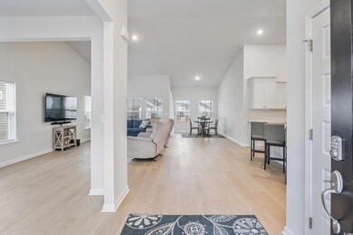 Living room with high vaulted ceiling and light wo