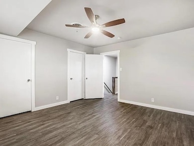 Unfurnished bedroom with dark wood finished floors and a ceiling fan