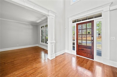 Entryway with a healthy amount of sunlight, decorative columns, visible vents, and wood finished floors