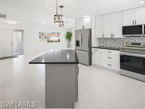 Kitchen featuring a kitchen island, white cabinetr