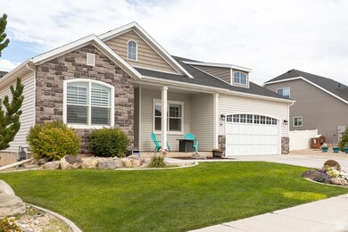 Craftsman-style house featuring stone siding, driveway, a garage, covered porch, and a shingled roof