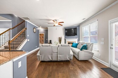 Living room with a lit fireplace, stairway, dark w