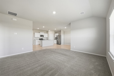 Unfurnished living room with light colored carpet, recessed lighting, and lofted ceiling